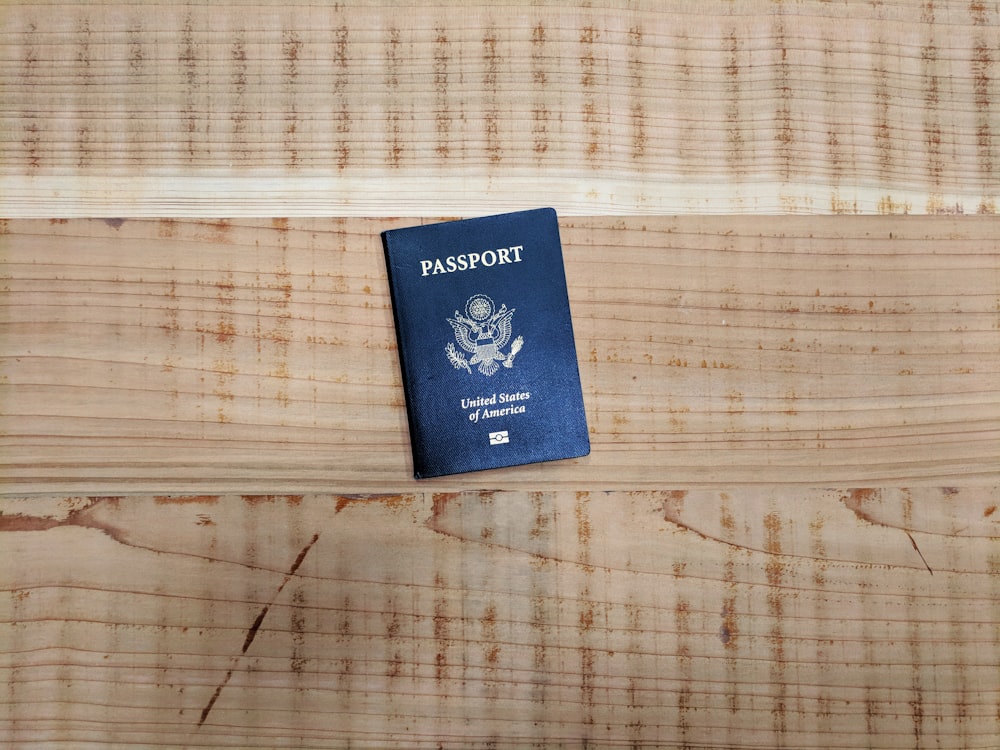 A photo showing an American passport resting on a wood surface.
